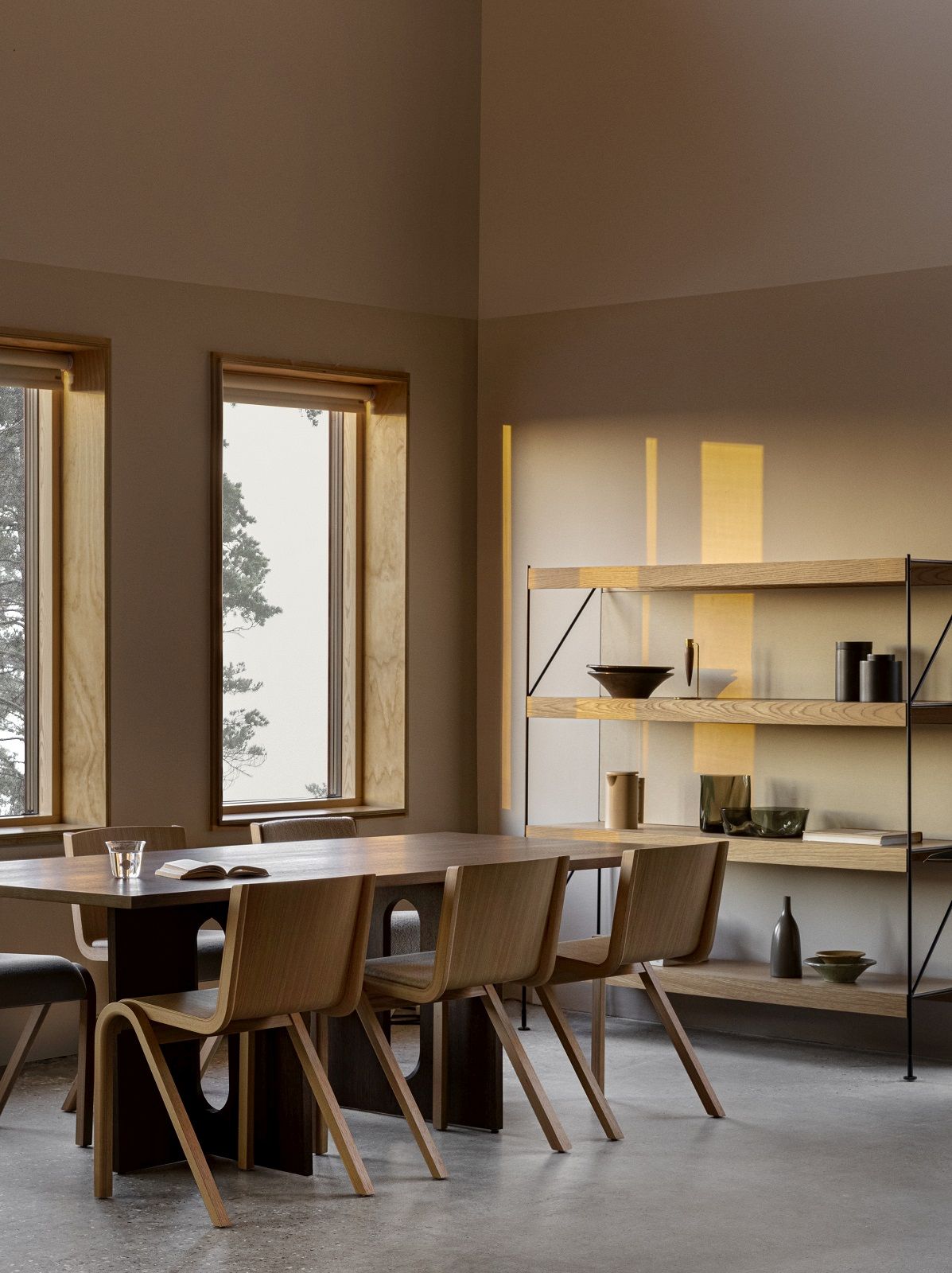 Esszimmer mit Holztisch, Stühlen und dem Audo Copenhagen Zet Storage System Regal mit Deko.