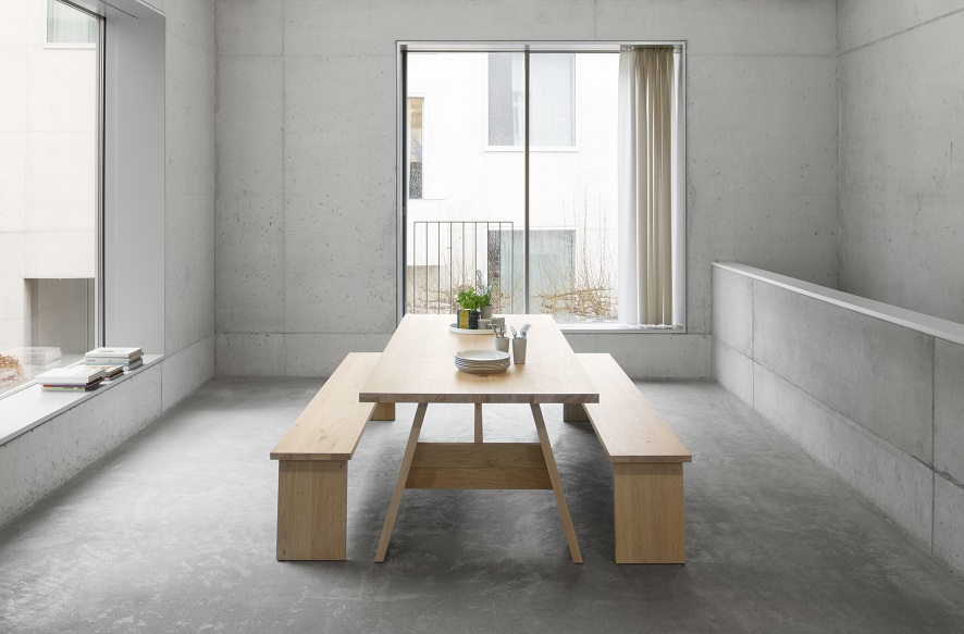 DC01 Fayland Tisch von e15, Esstisch aus geölter Eiche mit zwei passenden Bänken im minimalistischen Raum.