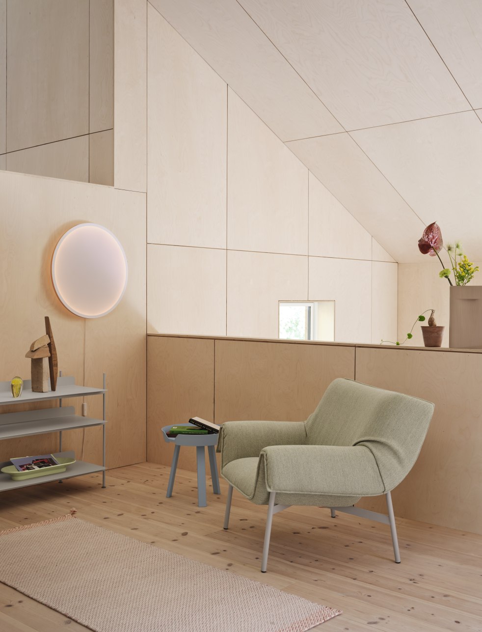 Helle Inneneinrichtung mit Muuto Calm Wall Lamp Wandleuchte, Sessel und Holzverkleidung.