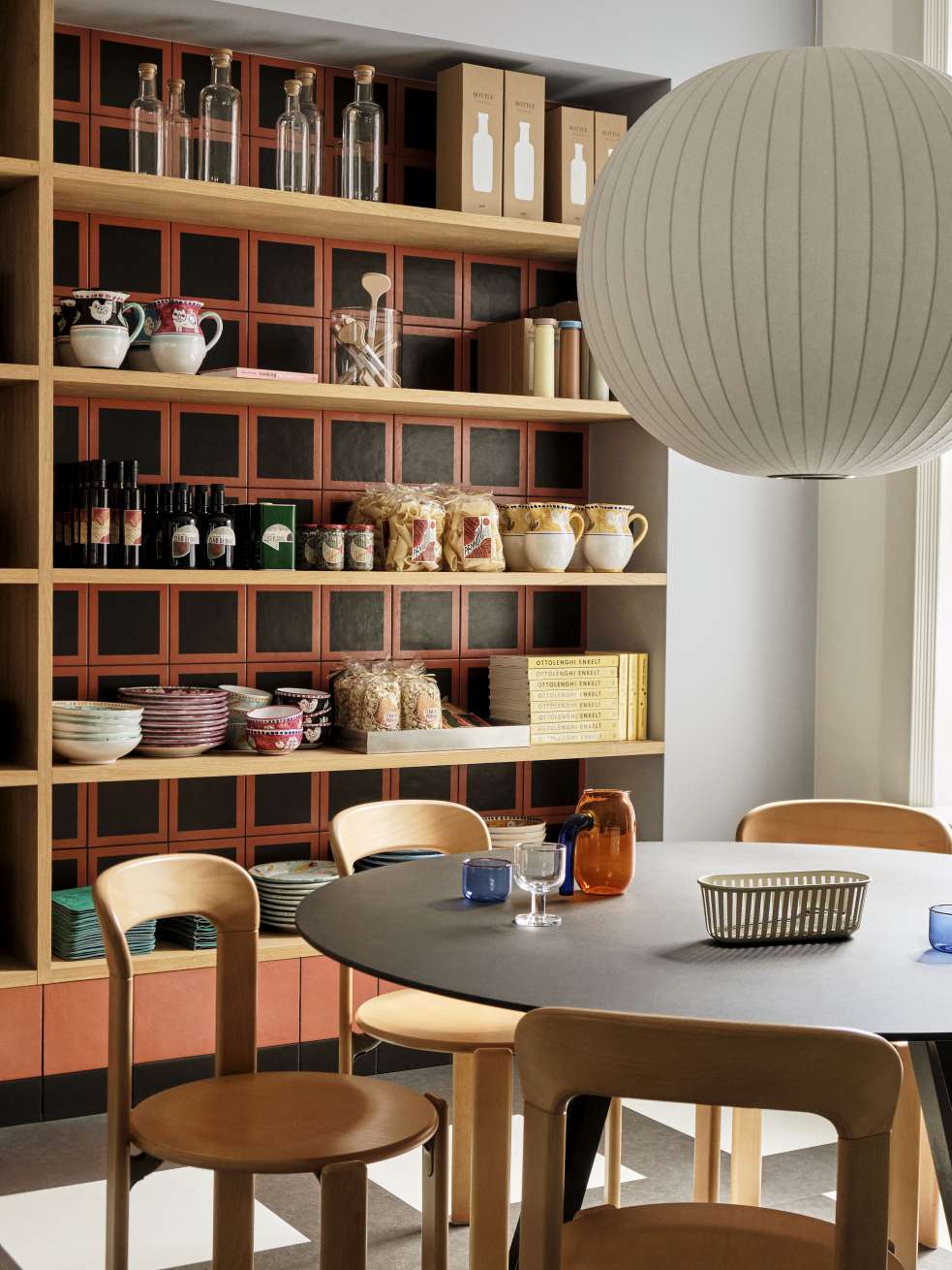 Hay Copenhague CPH 25 runder Esstisch mit Holzstühlen in modernem Esszimmer mit Regalwand.