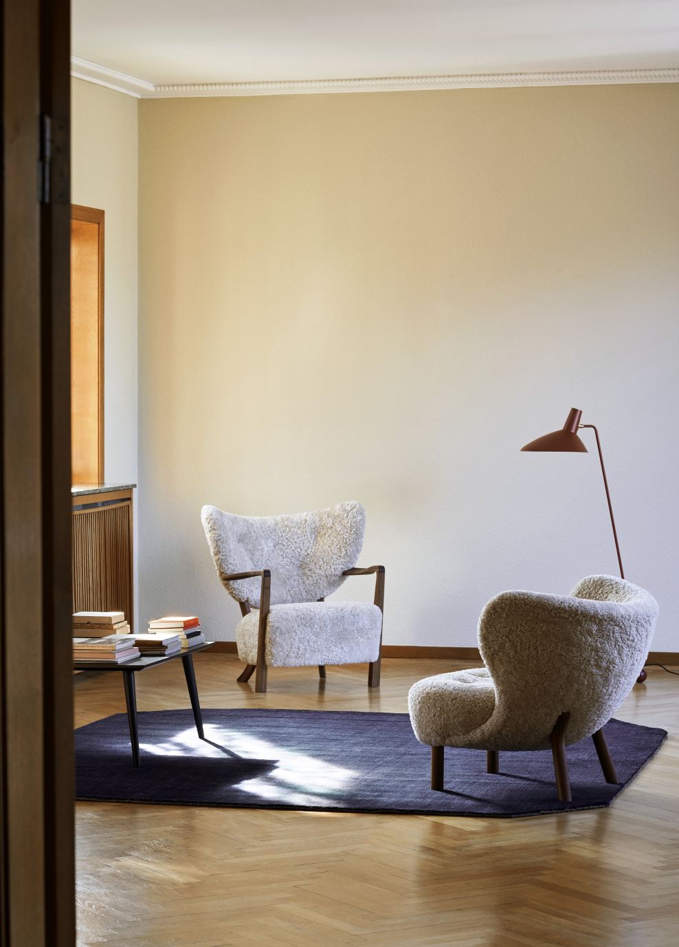 Wohnzimmer mit AndTradition In Between Couchtisch SK23, Sesseln und Teppich auf Parkettboden.