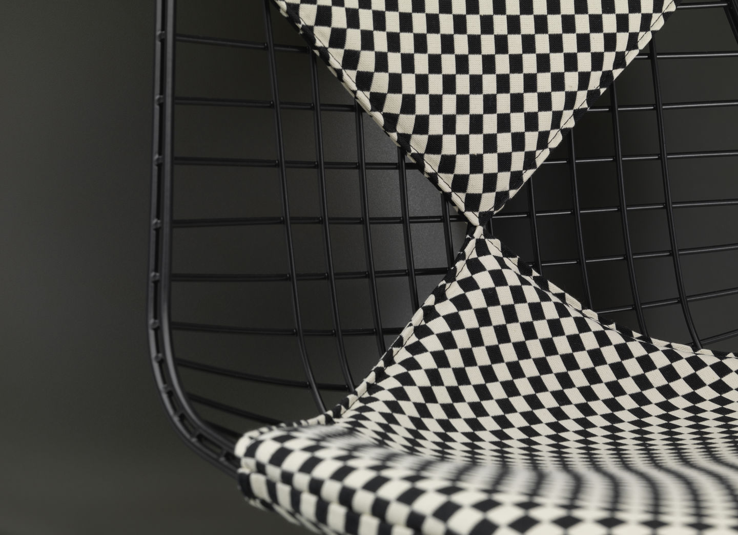 Detailaufnahme von Vitra DKW Wire Chair mit Sitz- und Rückenpolster im Schachbrettmuster.
