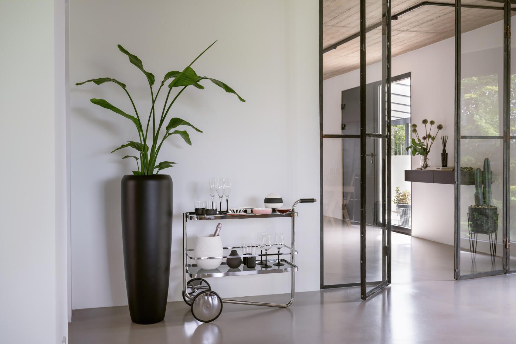 Thonet S 179 Barwagen aus Stahlrohr mit Gläsern und Dekoration in modernem Interieur.