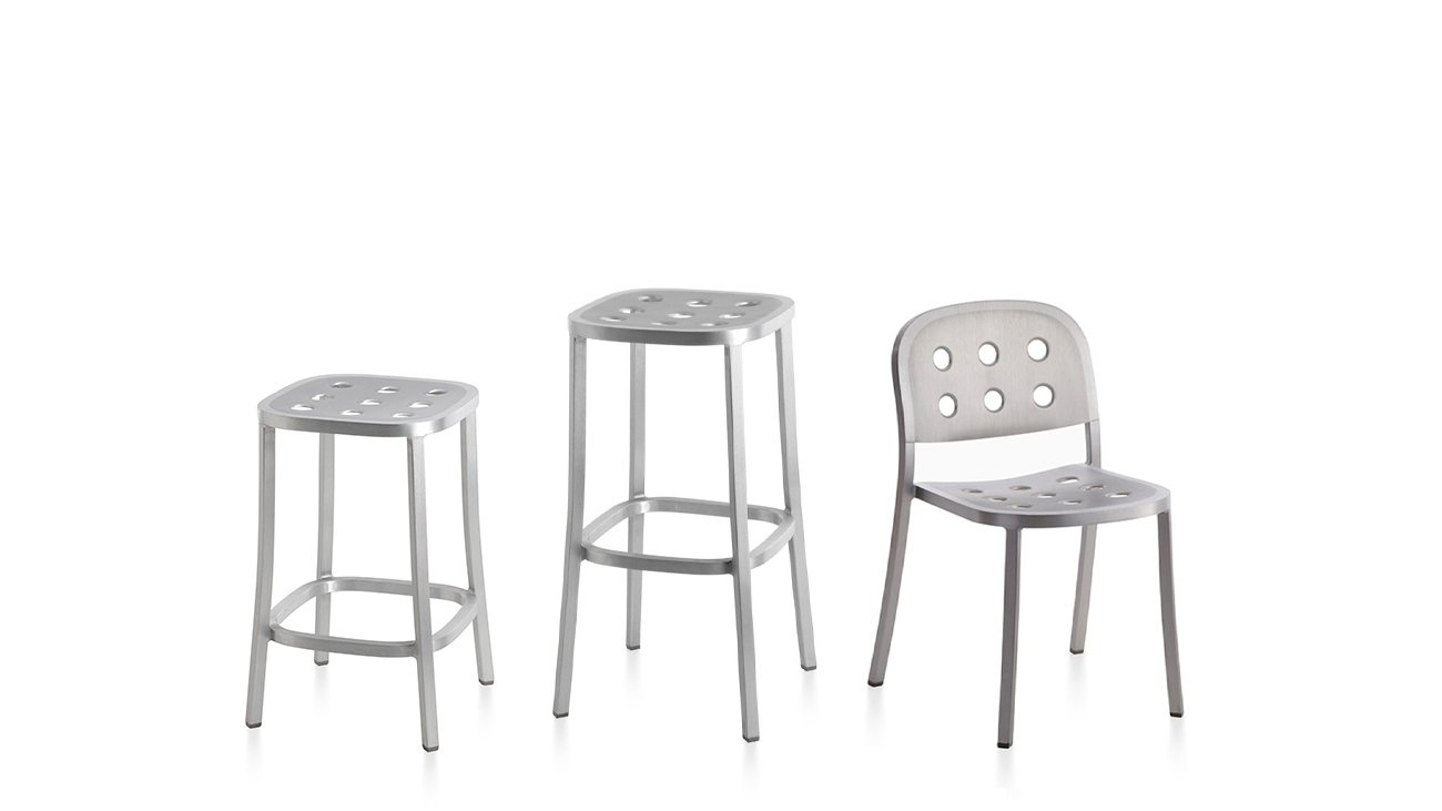 Drei Emeco 1 Inch Aluminium Hocker und Stuhl mit Löchern auf weißem Hintergrund.