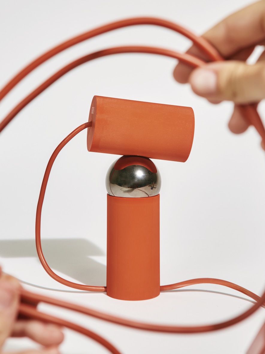 Orangefarbene Bilboquet Tischleuchte von Flos, modernes Design mit geometrischen Formen und Kabel.