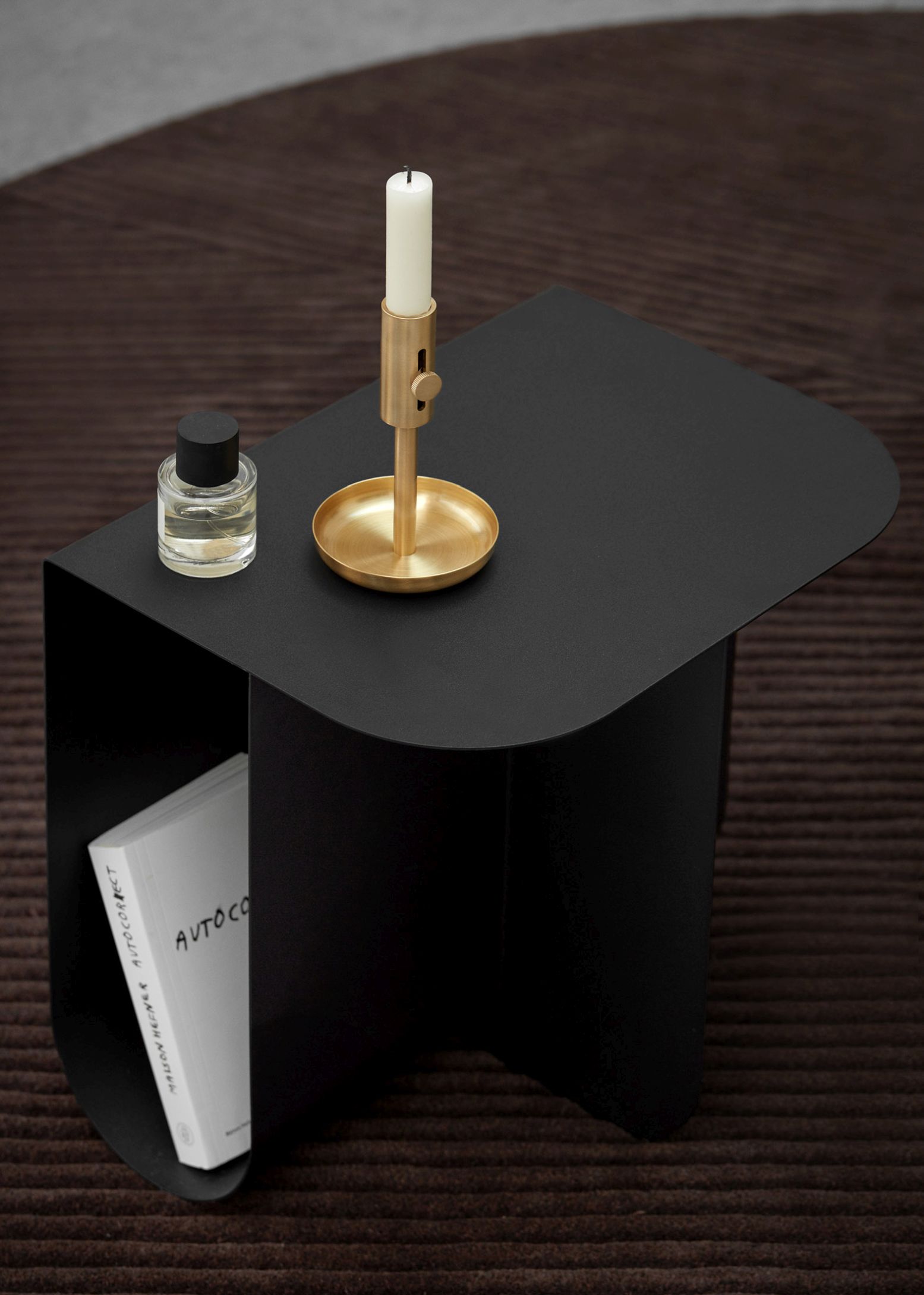 Schwarzer Mass Beistelltisch aus Stahl von Northern mit Kerzenständer und Buch im minimalistischen Design.