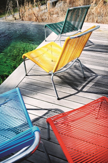 Altorfer Lounge Stuhl Outdoor Embru in verschiedenen Farben auf einer Holzterrasse am Pool. Gartenmöbel.