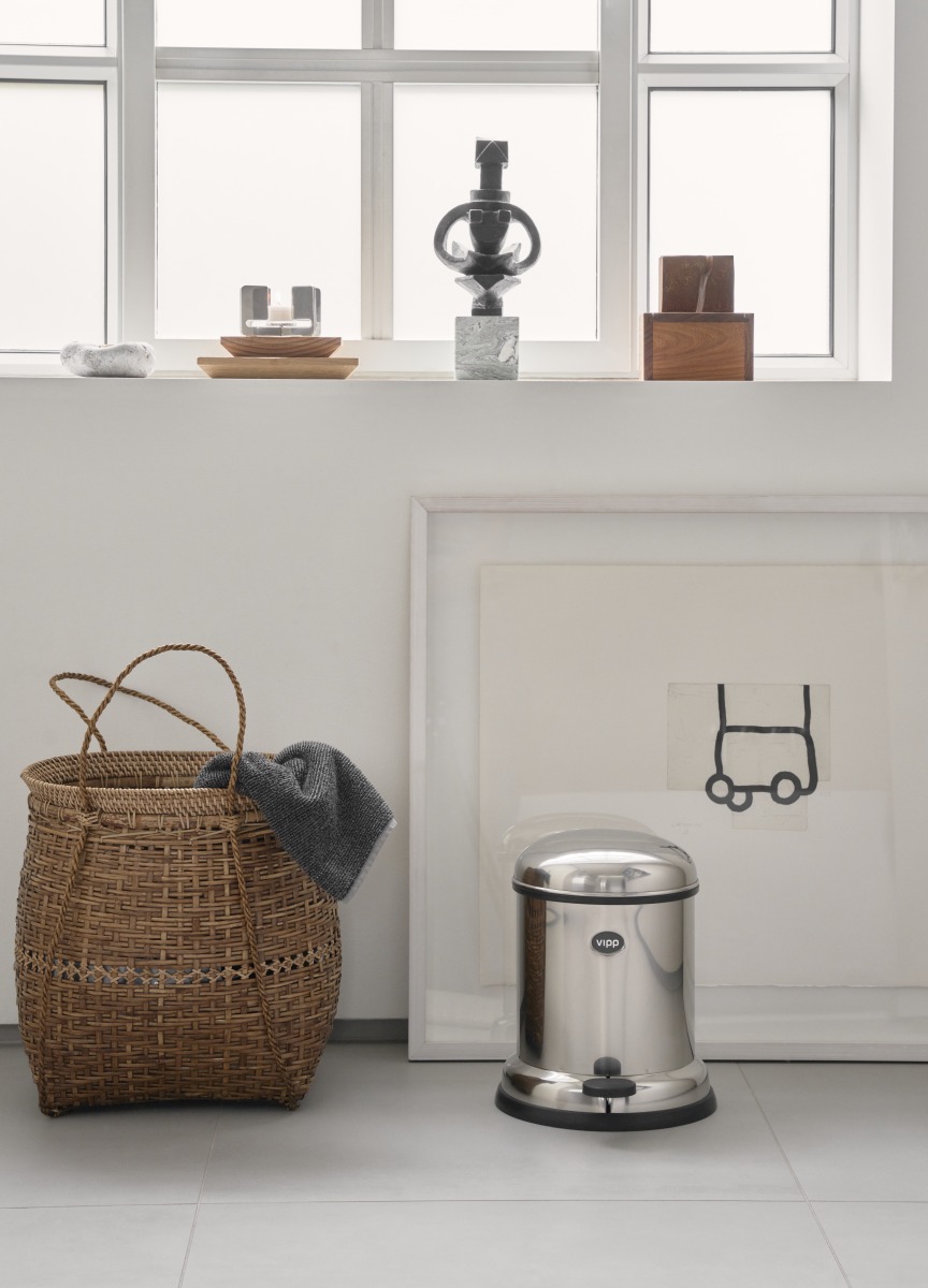 Vipp Treteimer 4L aus Edelstahl im Badezimmer, neben Korb und Kunstwerk.