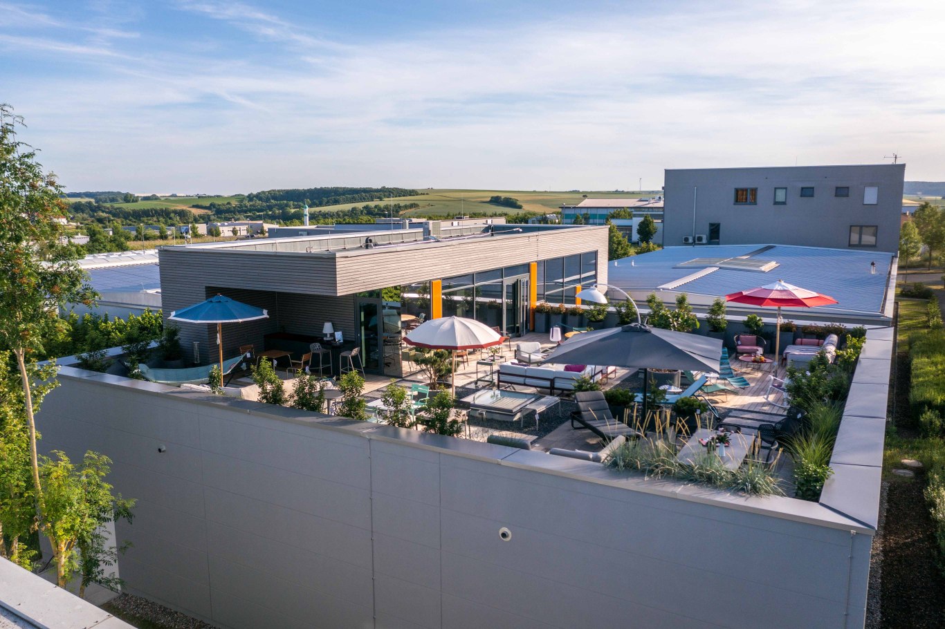 Dachgarten mit Loungemöbeln, Sonnenschirmen und Pflanzen für entspannte Stunden im Freien. Gartenmöbel für Terrasse und Balkon.