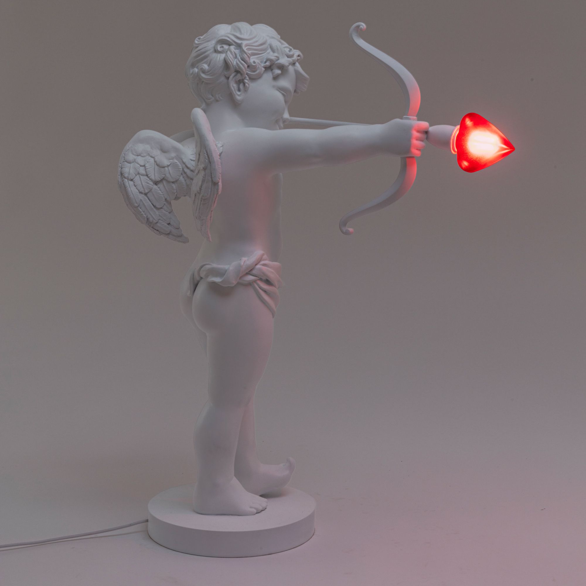 Weiße Cupid Lampe von Seletti: Amor Figur mit Pfeil und Herz als Tischleuchte.