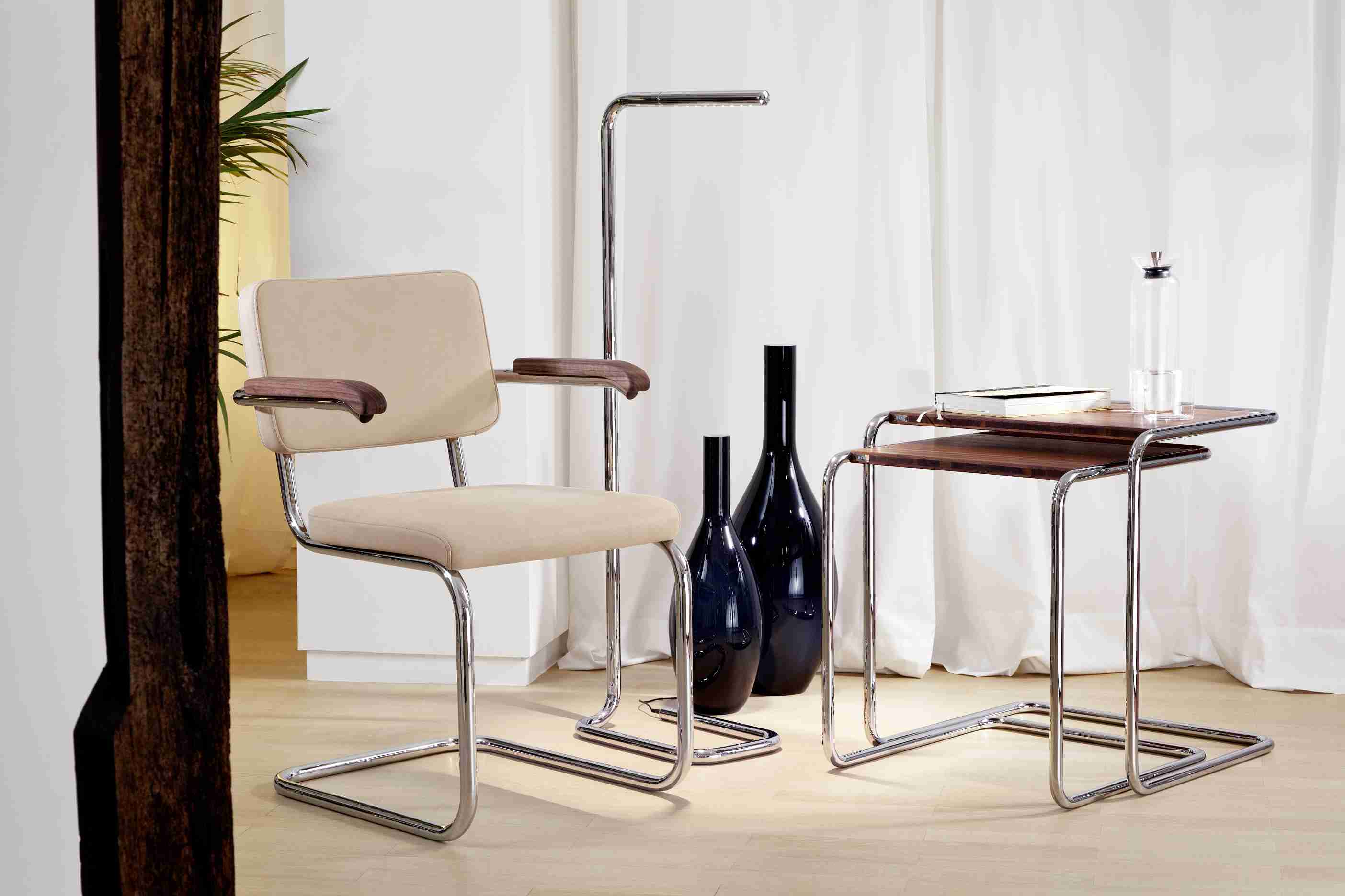 Lum LED Stehleuchte von Thonet, verchromt, im modernen Wohnambiente mit Sessel und Beistelltisch.