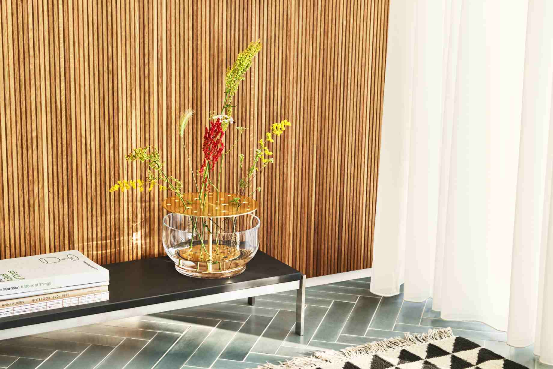 Nahaufnahme des Fritz Hansen PK62 Couchtisches mit Blumen in einer Glasvase auf einem modernen Tisch.
