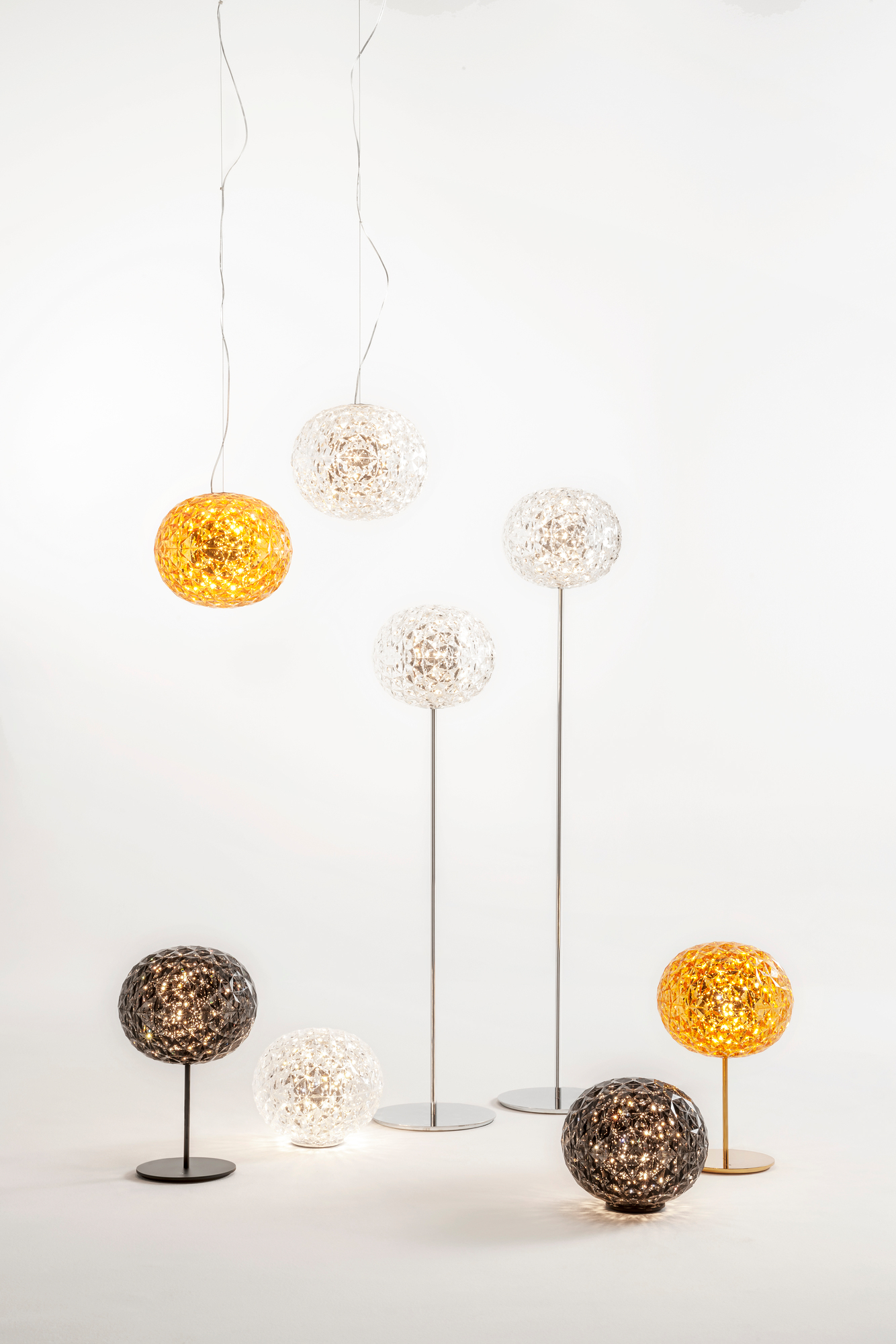 Verschiedene Kartell Planet Leuchten: Pendelleuchten, Stehleuchten und Tischleuchten in Gold, Schwarz und Kristall.