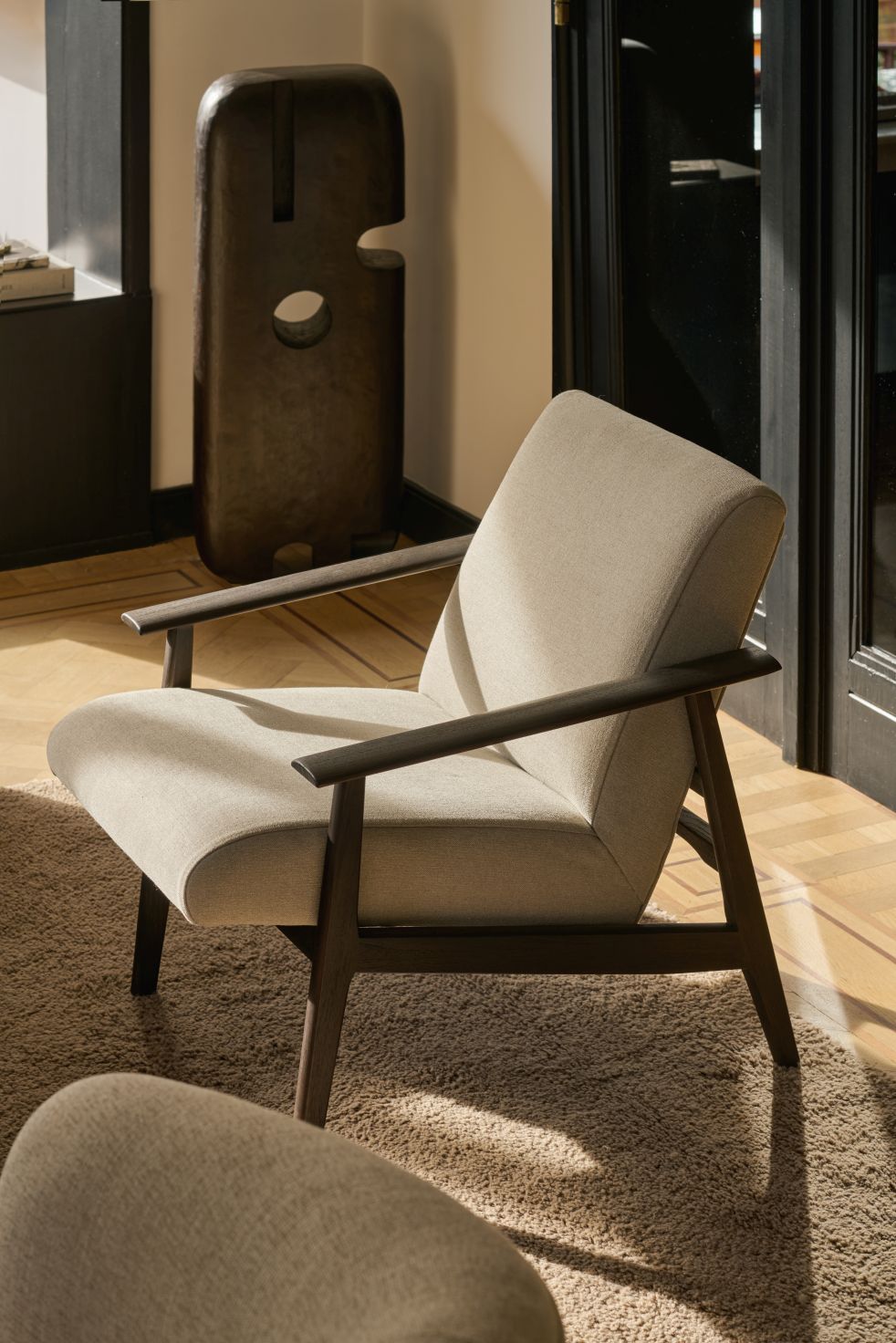 Aspekt Sessel von Ethnicraft, beiger Stoffbezug und dunkles Holzgestell, modernes Wohnzimmer-Design.