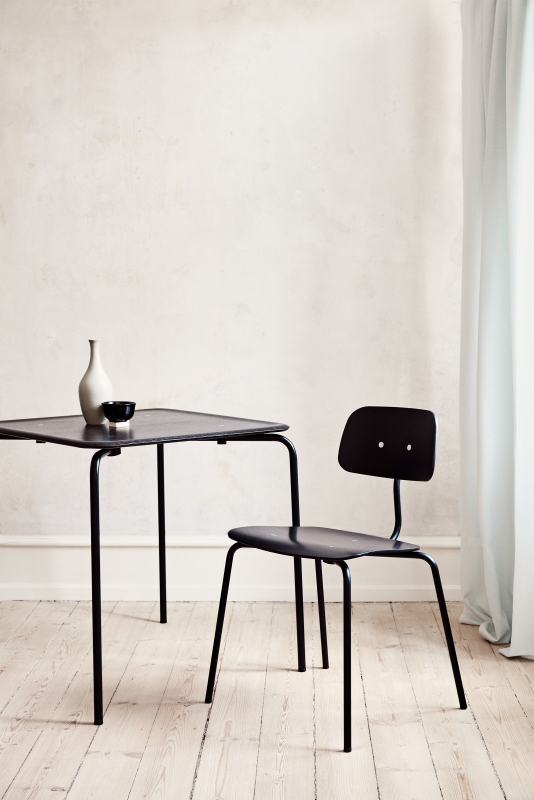 Schwarzer Kevi 2060 Stuhl von Montana mit Tisch und minimalistischer Dekoration vor hellem Hintergrund.