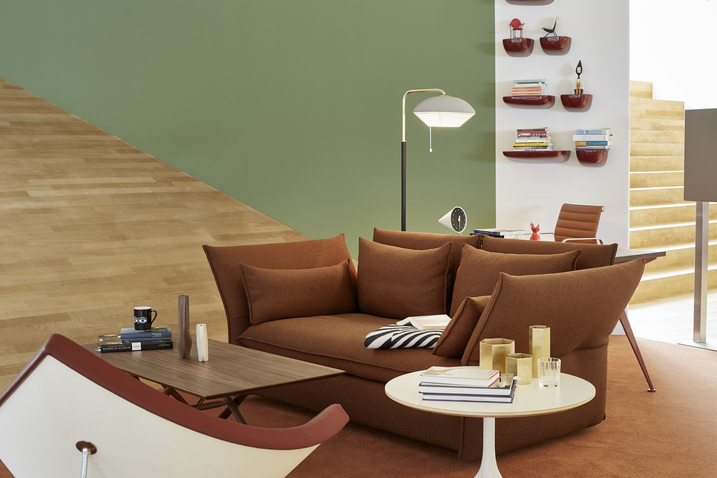 Wohnzimmer-Szene mit Vitra Corniches Wandboards in Rot, die an einer weißen Wand montiert sind.