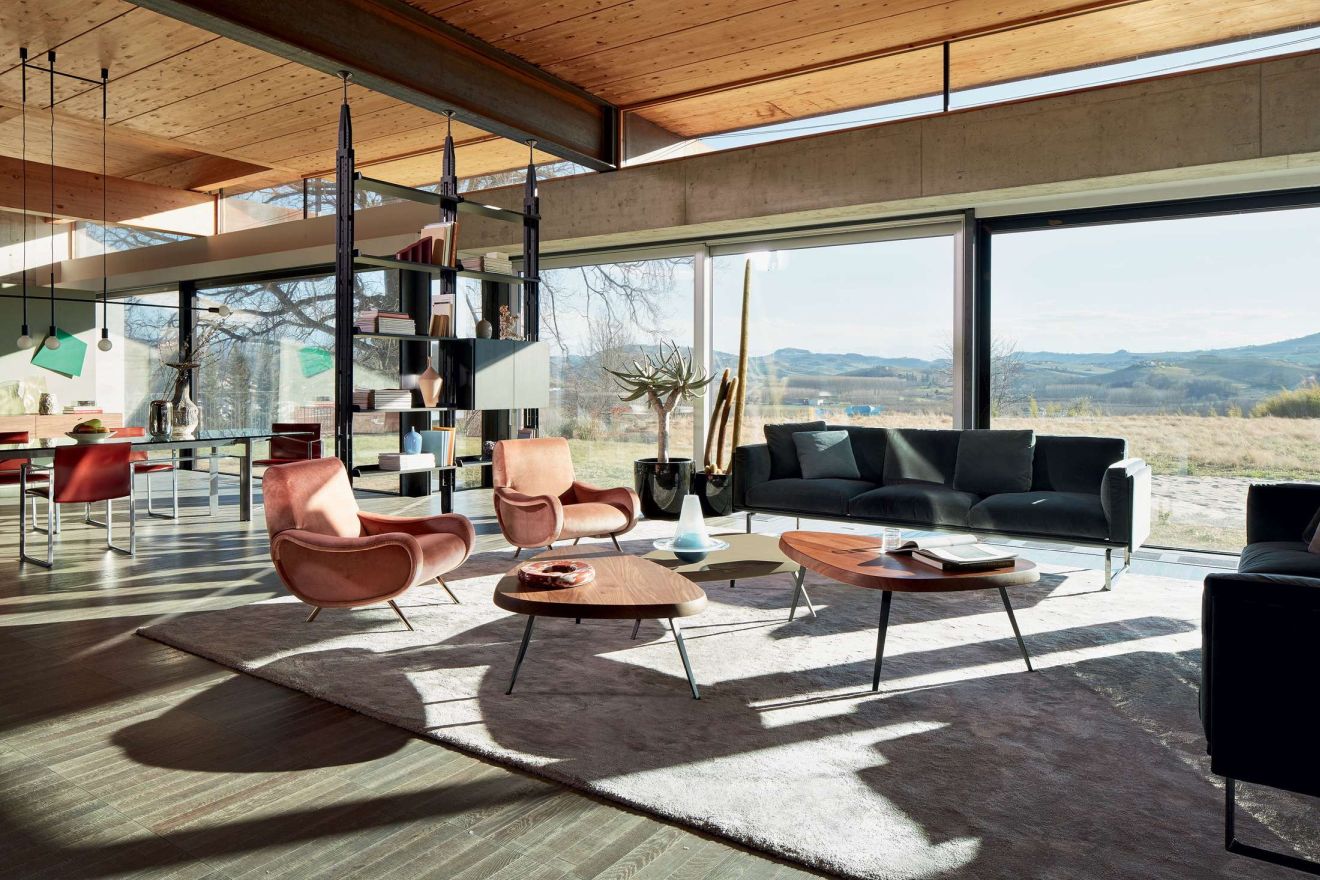 Wohnzimmer mit zwei rosafarbenen 720 Lady Sesseln von Cassina, Designermöbel und großem Fenster.