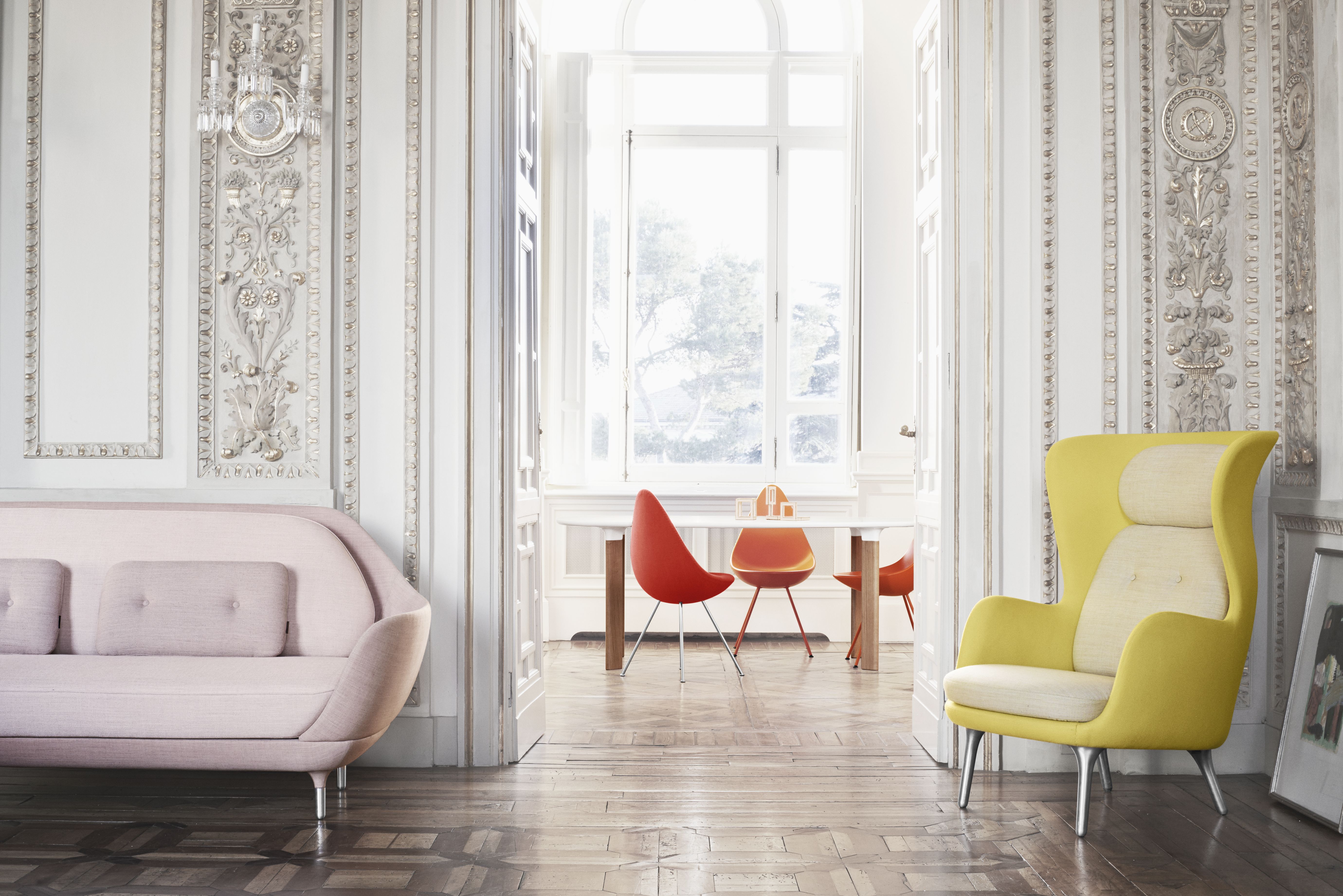 Gelber Fritz Hansen Ro Sessel aus Holz, kombiniert mit Sofa und Esstisch in stilvollem Interieur.