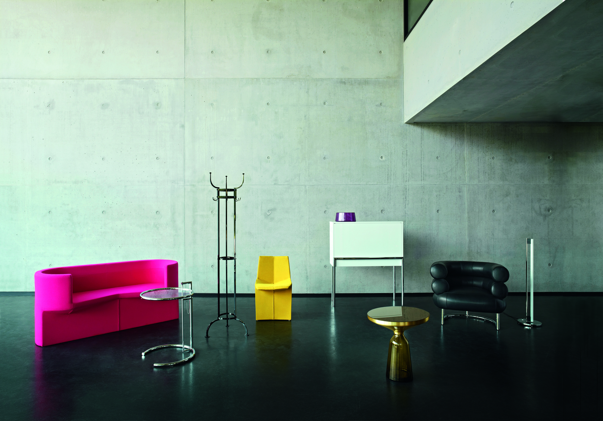 Minimalistisches Interieur mit ClassiCon E1027 Beistelltisch, verstellbar, mit Glasplatte und verchromtem Gestell neben pinkem Sofa.