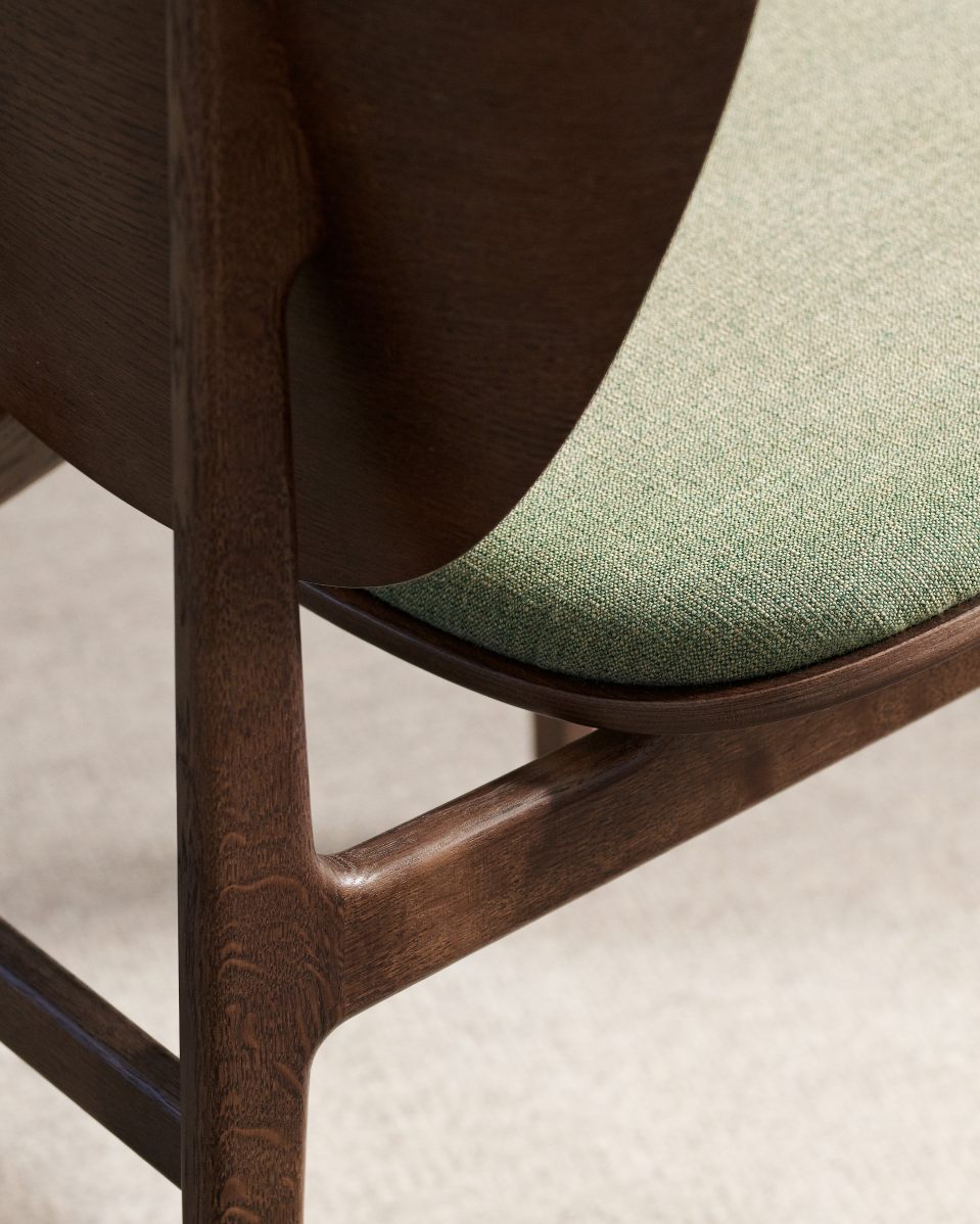 Detailaufnahme vom Elephant Dining Chair Stuhl mit grüner Polsterung und dunklem Holzgestell.