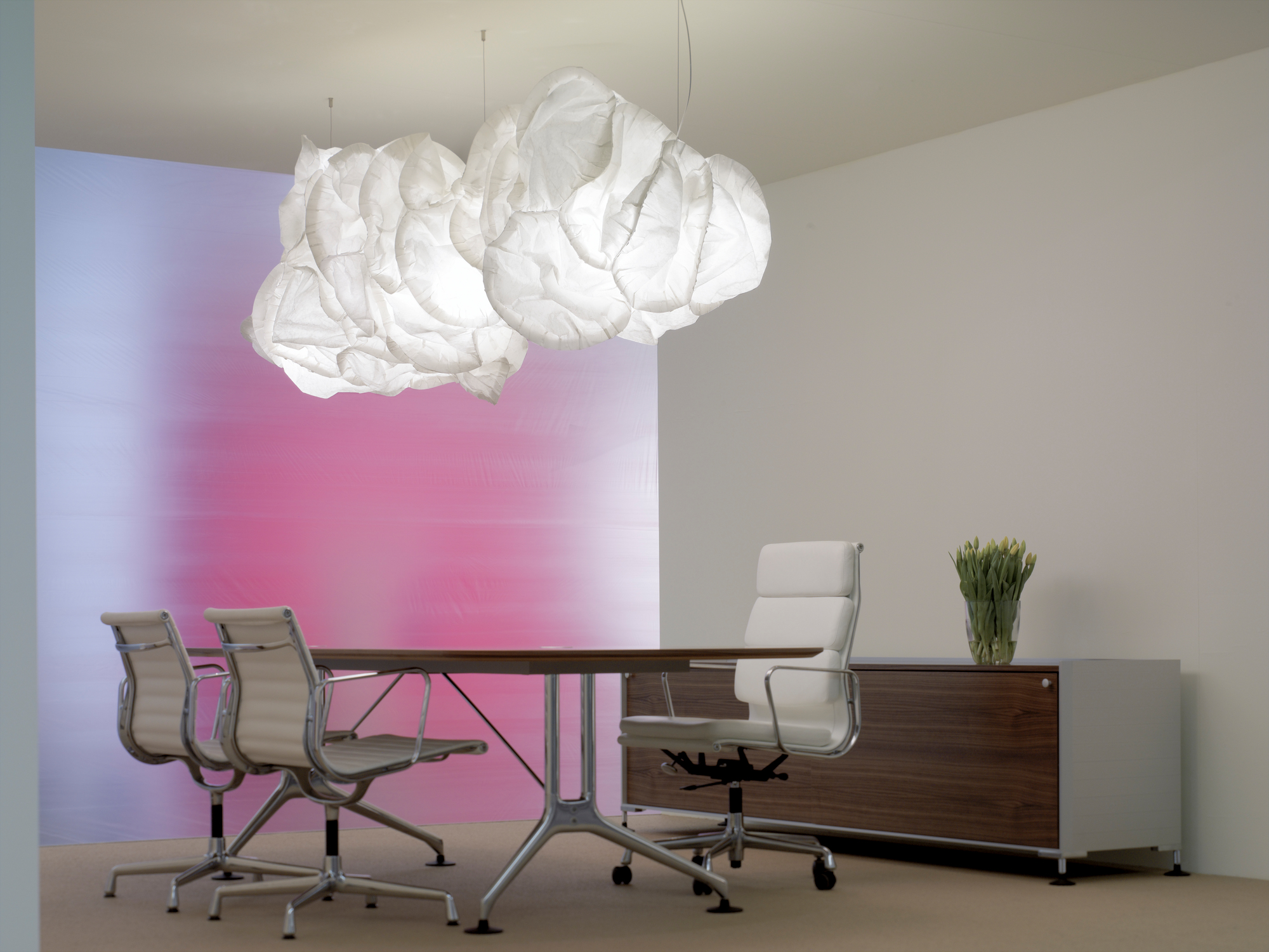 Nahaufnahme der Belux Mamacloud Pendelleuchte, die über einem Konferenztisch in einem modernen Büro hängt.