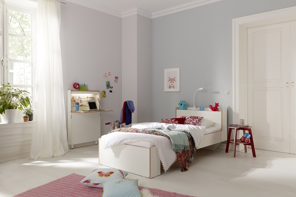 Nook Einzelbett von Müller Möbelwerkstätten im Kinderzimmer mit Schreibtisch und Dekoration.