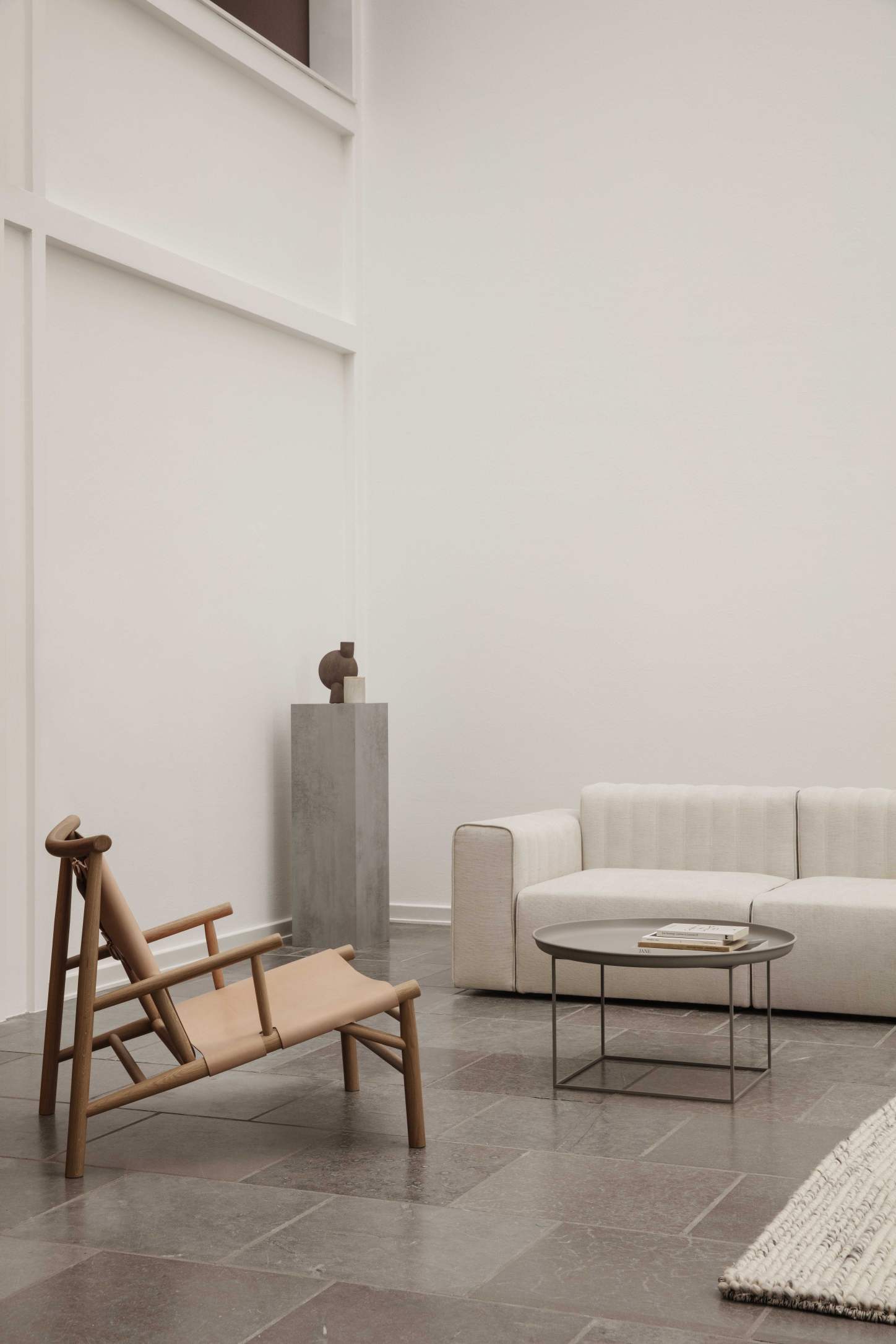 Samurai Lounge Chair Sessel von NORR11 mit hellem Leder und Holzgestell in modernem Wohnzimmer.