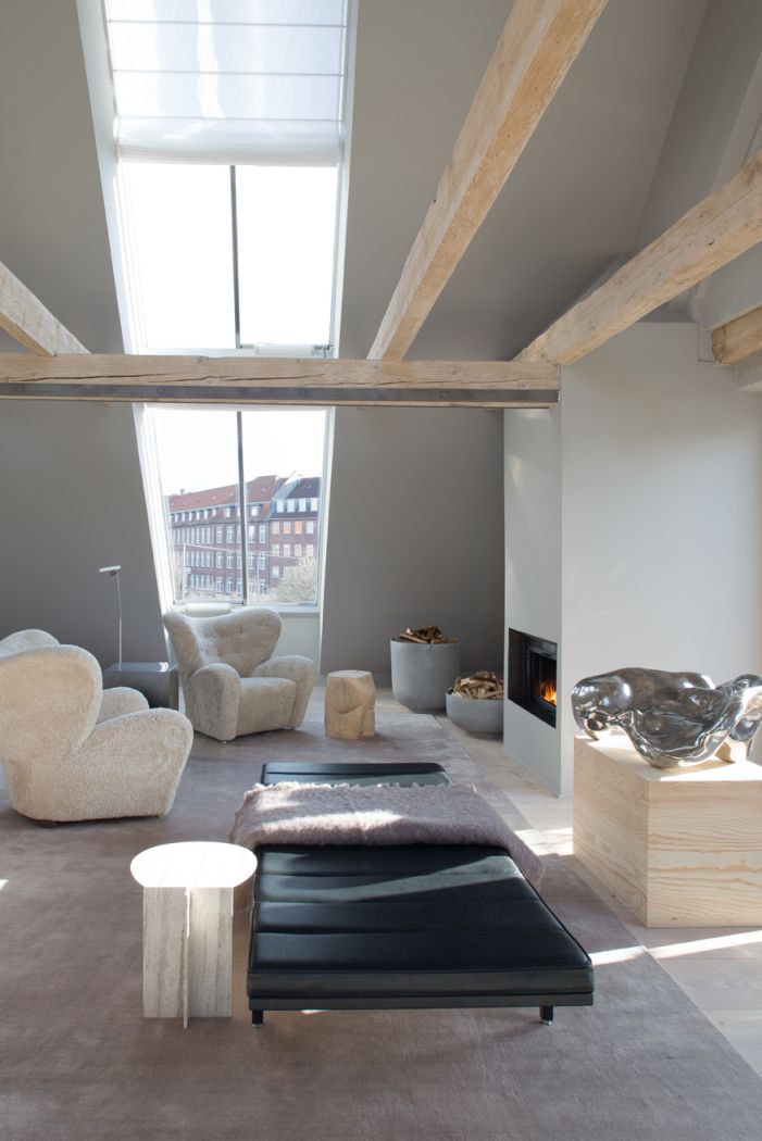 Helles Wohnzimmer mit Vipp Daybed, Sesseln, Kamin und Dachfenster für entspanntes Wohnen.