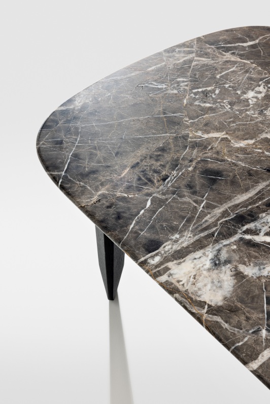Detailaufnahme der Marmorplatte des Kuyu Marble Couchtisches mit einzigartiger Maserung und einem dunklen Holzbein.