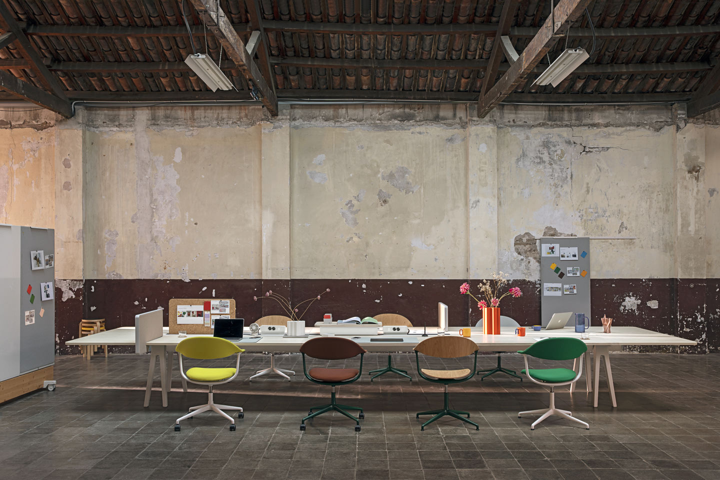 Mynt Bürodrehstühle von Vitra aus Kunststoff in verschiedenen Farben an einem langen Bürotisch.