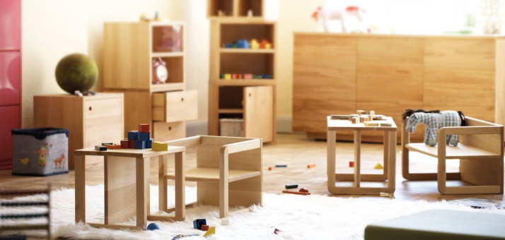 Kinderzimmer mit Holzmöbeln: Tisch, Stühle, Regale und Spielzeug für Kinder. Natürliches Design für ein gemütliches Kinderzimmer.