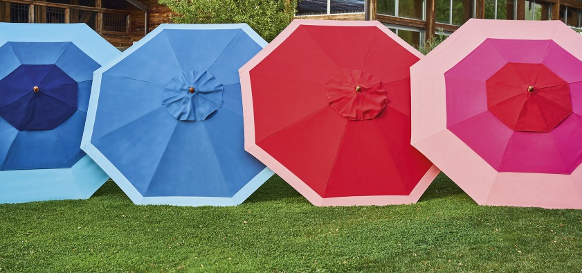 Weishäupl Klassiker Sonnenschirme in Blau, Rot und Pink auf Rasen für den Garten.