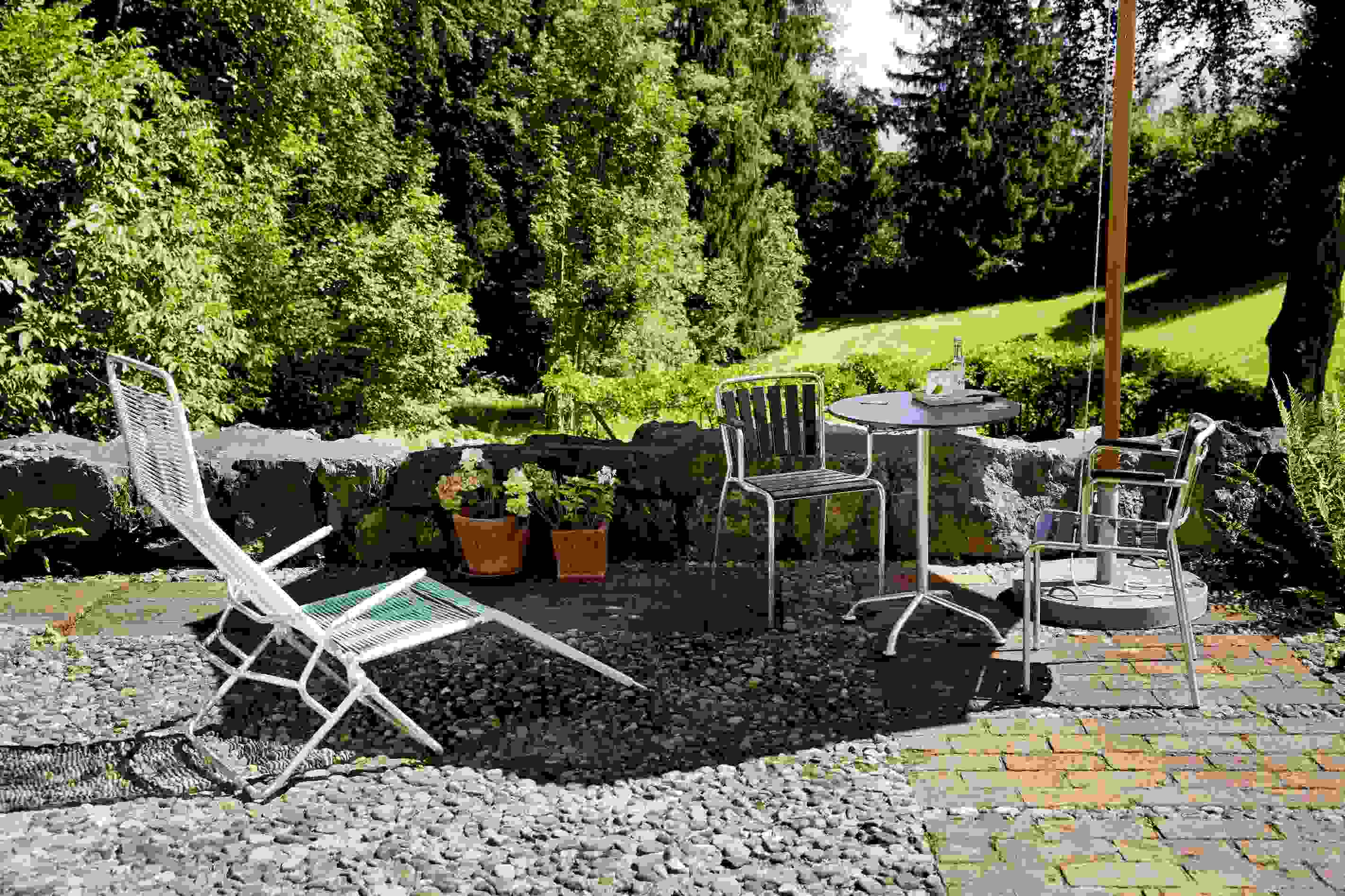 Altorfer Liegestuhl im Garten: Outdoor-Liege mit Tisch und Stühlen auf Terrasse.