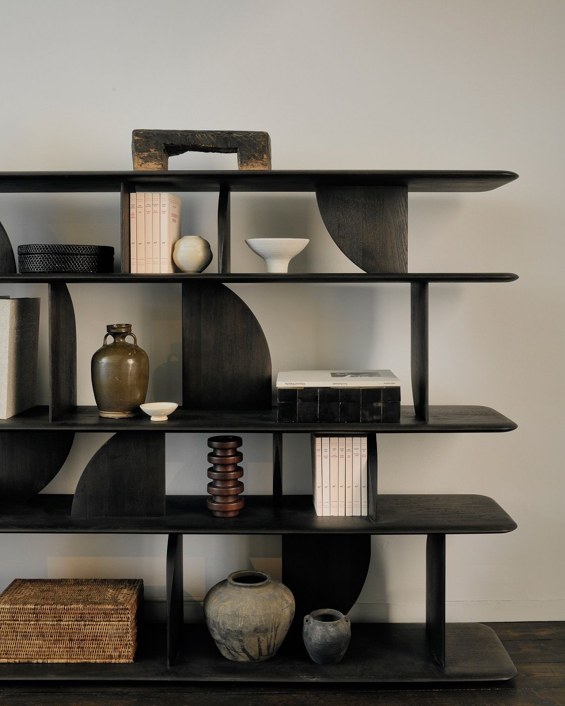 Ethnicraft Geometric Regal aus Teakholz, lackiert, mit Deko-Objekten in einem modernen Wohnzimmer.