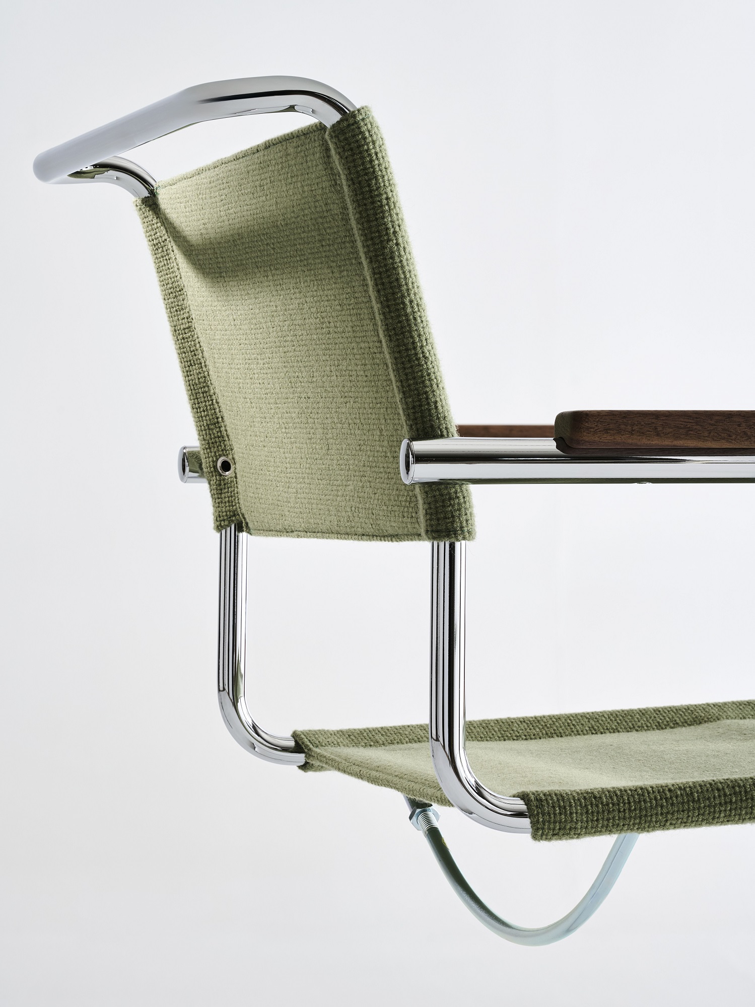 Detailaufnahme des Thonet S 34 V Freischwingers mit grünem Stoffbezug und verchromtem Stahlrohrgestell.