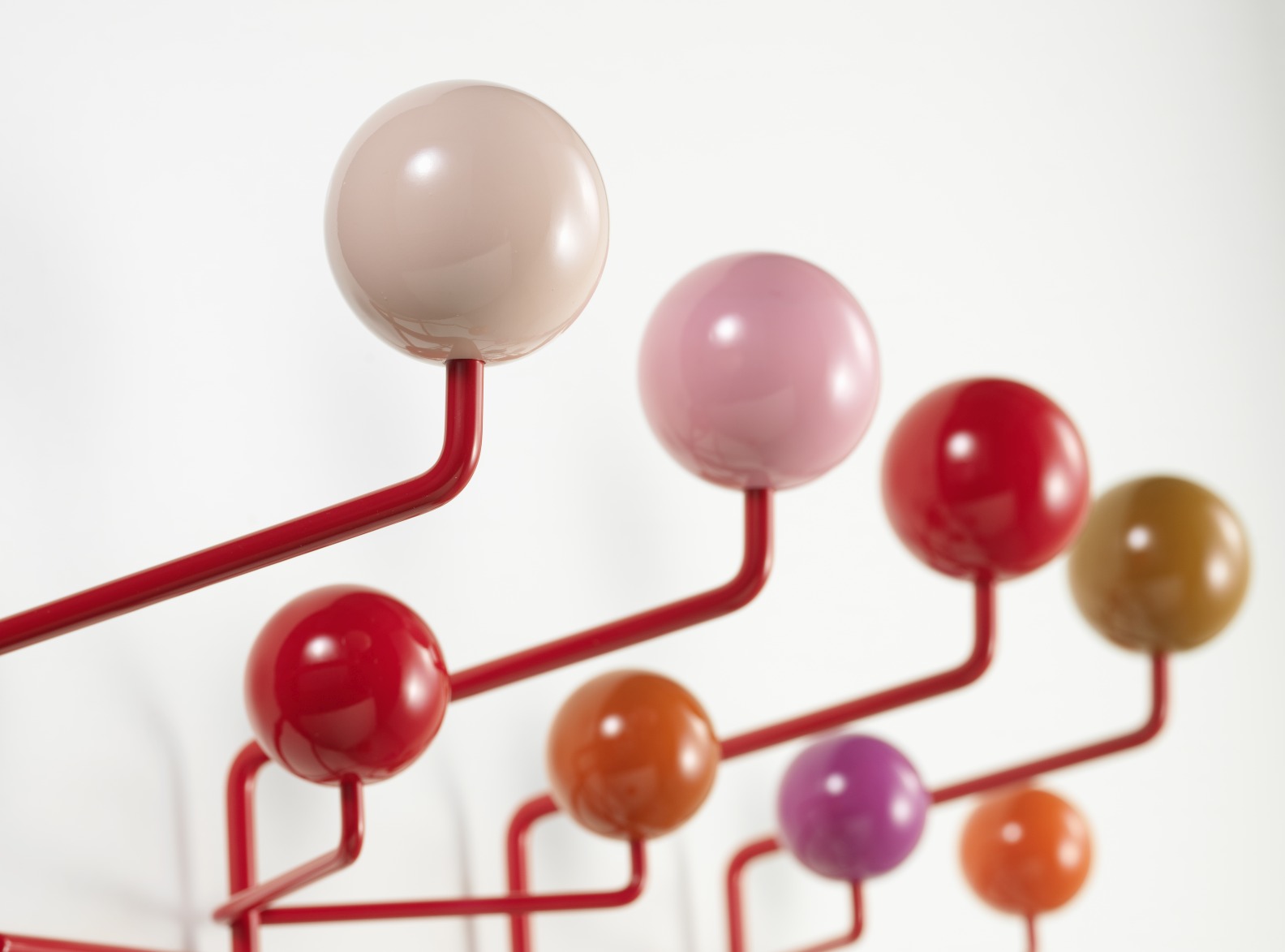 Detailaufnahme der Eames Hang it all Garderobe Warm von Vitra mit bunten Kugeln und rotem Gestell.