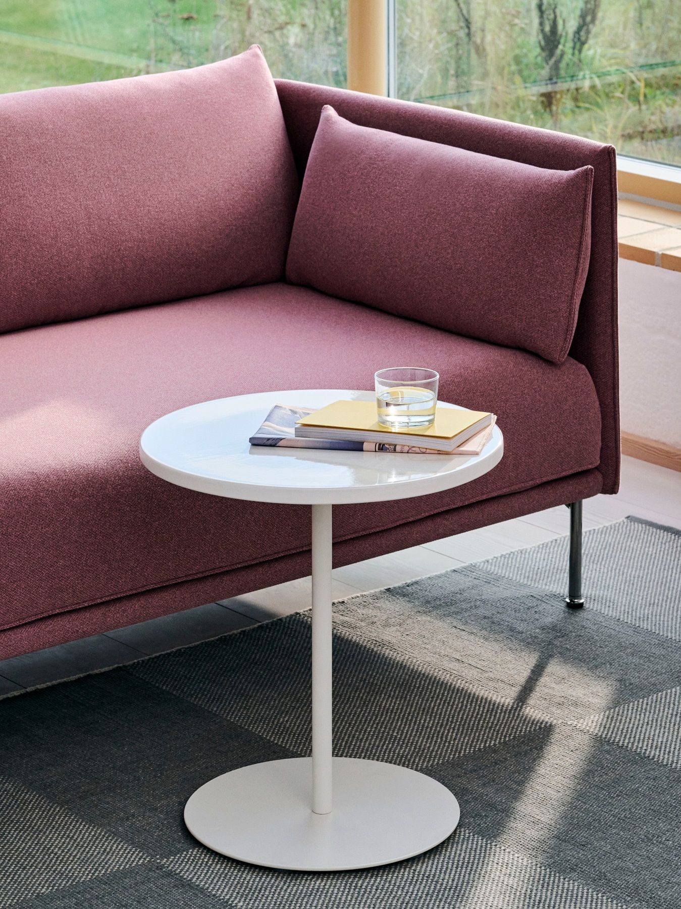 Nahaufnahme des weißen Hay Pyro Coffee Table Indoor/Outdoor Couchtisch neben einem modernen, rosafarbenen Sofa.