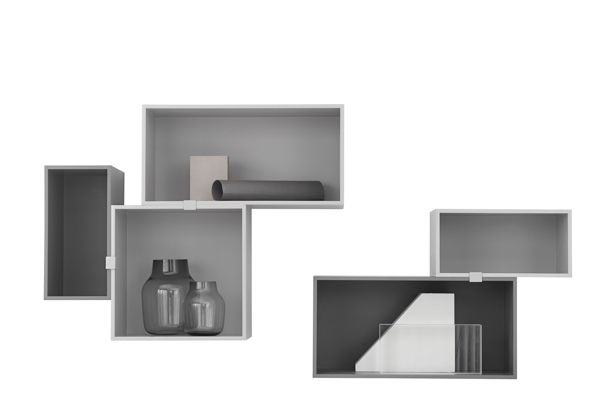 Muuto Mini Stacked Regalsystem 2.0 in Grau und Weiß mit dekorativen Vasen und Objekten.