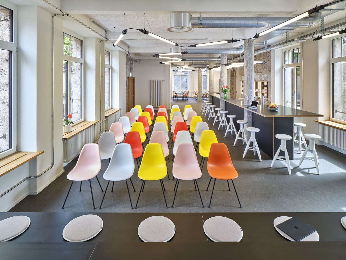 Eames Fiberglass Chair DSX Stühle von Vitra in verschiedenen Farben in einem Konferenzraum.