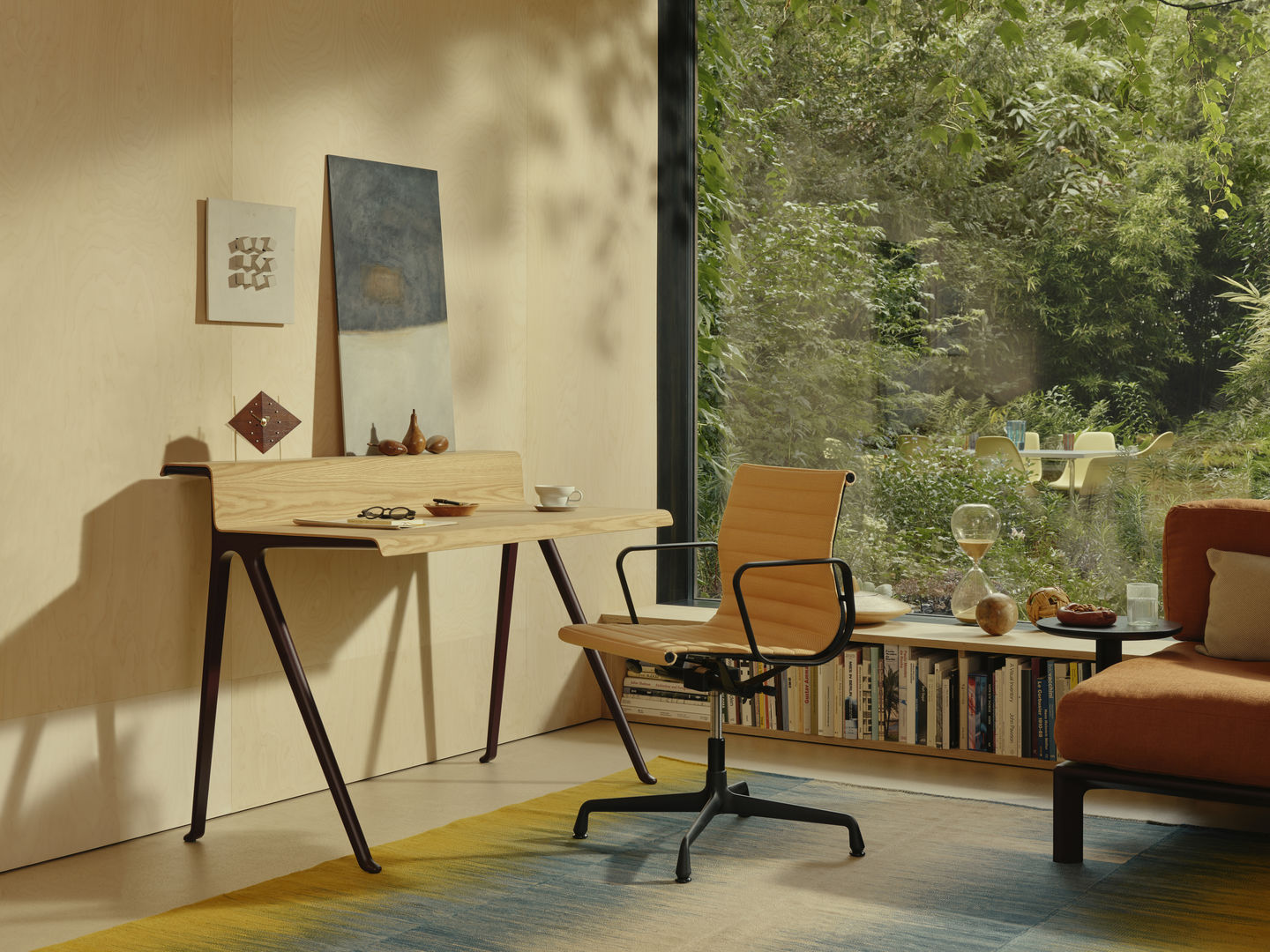 Vitra Schreibtisch Courier aus hellem Holz mit dunklen Beinen in modernem Wohnraum.