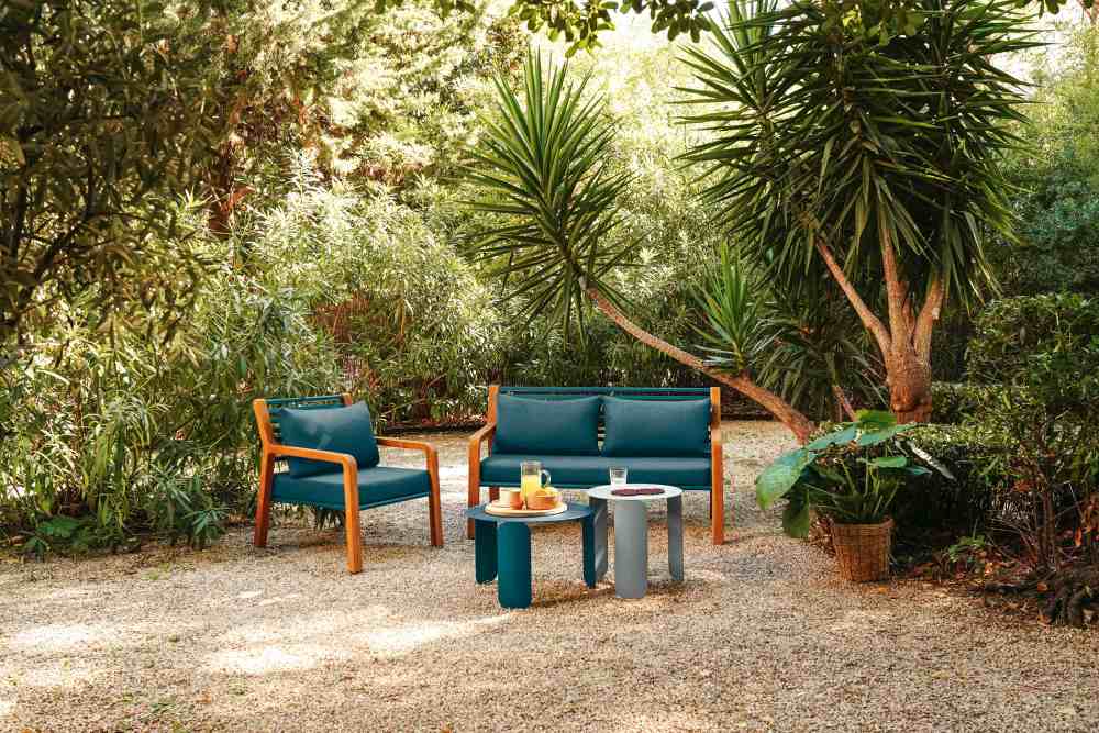 Somerset Sessel und Sofa von Fermob im Garten, blaue Outdoor-Möbel mit Holzelementen.