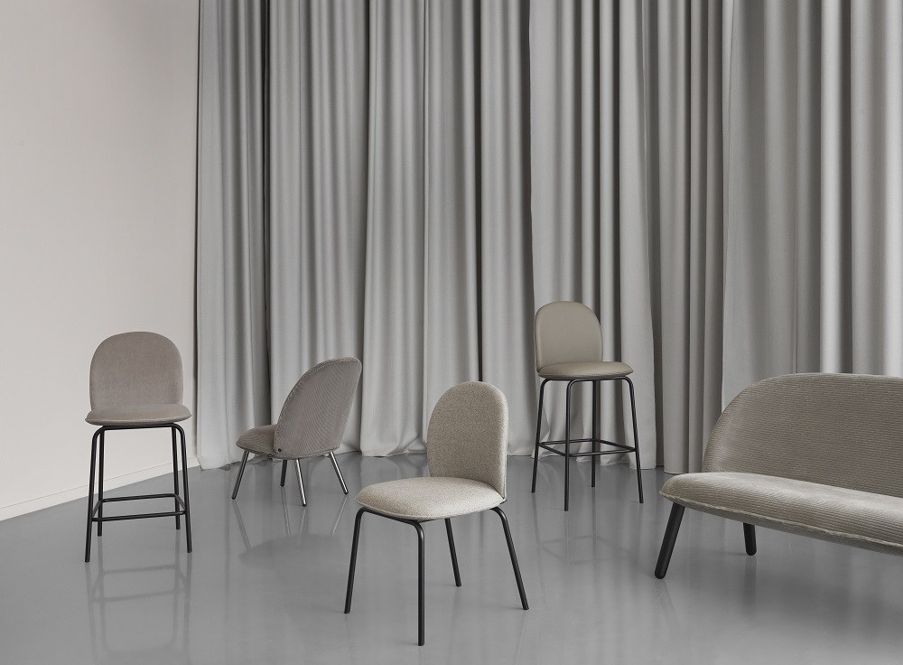 Graue Ace Chair Stühle von Normann Copenhagen mit Polsterung und schwarzen Metallbeinen vor grauem Vorhang.
