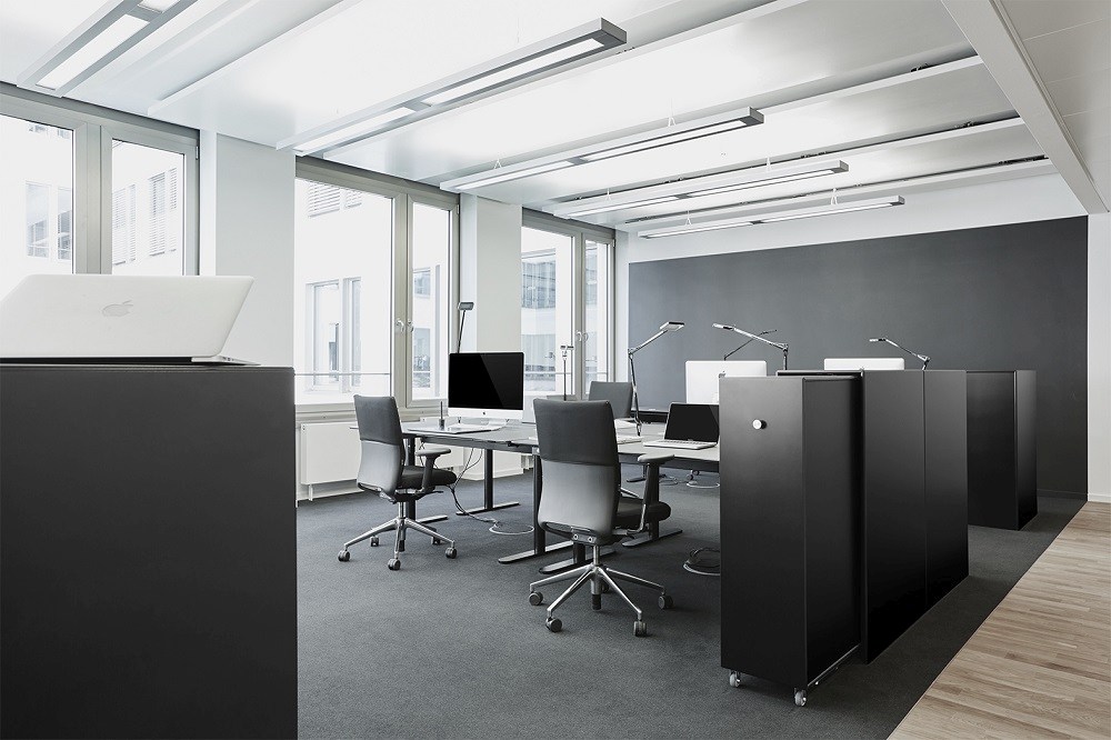 Modernes Büro mit schwarzem Montana Cargo Modul 80 Schrank-System zur Aufbewahrung und als Raumteiler.