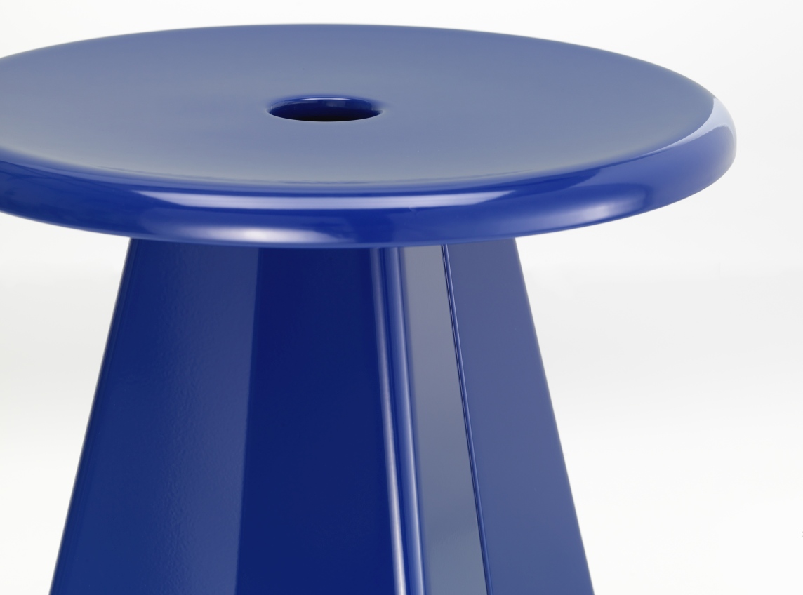 Nahaufnahme des blauen Vitra Tabouret Métallique Hockers mit runder Sitzfläche und konischem Fuß.