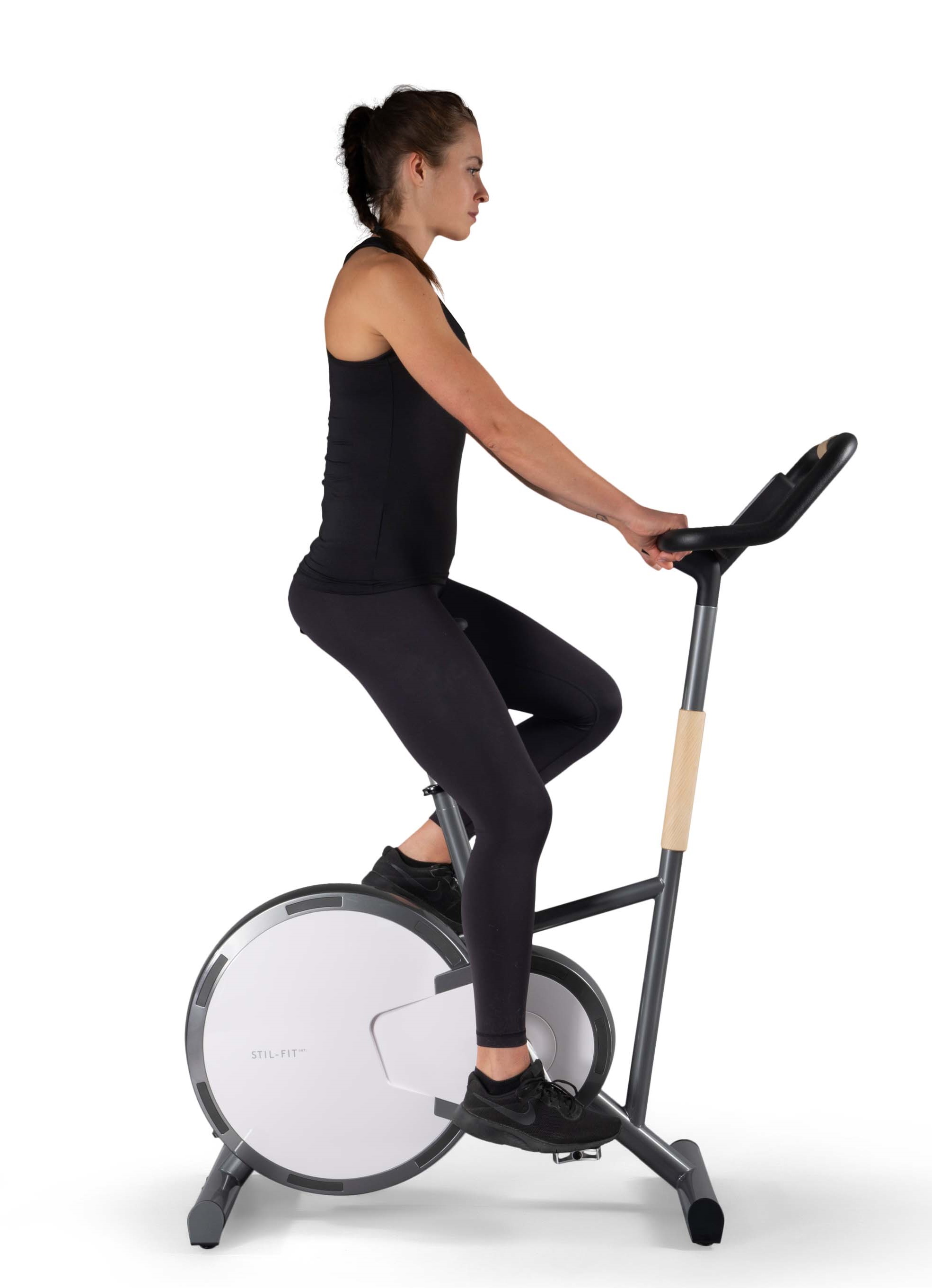 Frau trainiert auf dem Stil-Fit Ergometer in Walnuss-Schwarz für ein effektives Cardiotraining.