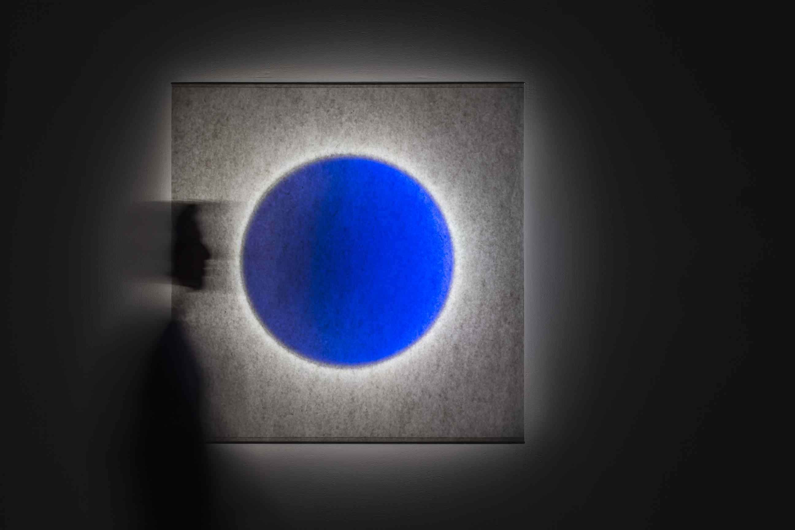 Moodmoon Wandleuchte: Quadratische Designerlampe von Ingo Maurer mit blauem Kreis und indirektem Licht.