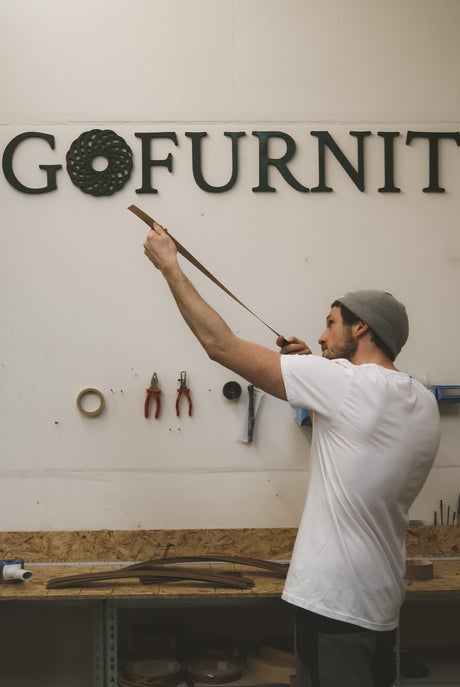 Handwerker in Werkstatt beim Möbelbau mit Holzleisten für hochwertige Möbel von GoFurnit.