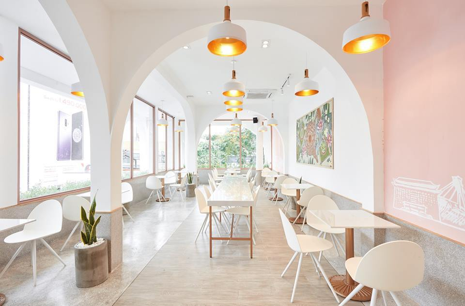 Innenaufnahme eines hellen Restaurants mit weißen Camel Stühlen von Segis und Tischen.