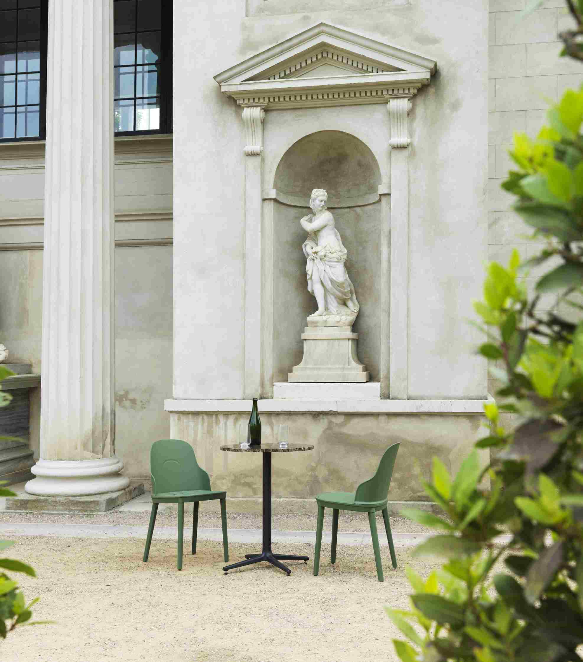 Zwei grüne Allez Chair Stühle von Normann Copenhagen mit Tisch im Außenbereich vor historischer Kulisse.
