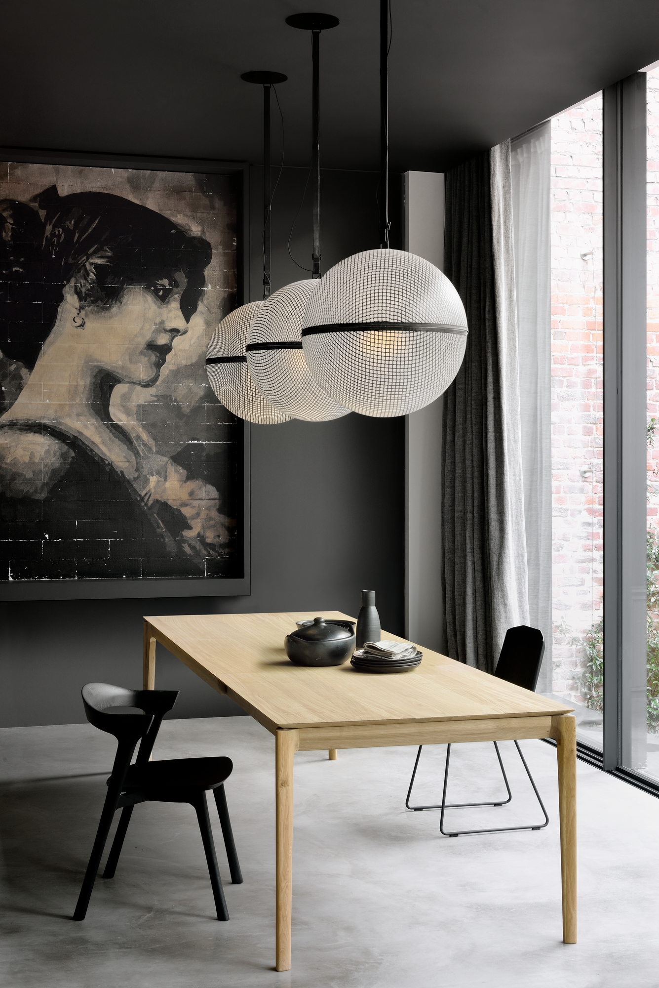 Bok Esstisch aus Eiche von Ethnicraft in modernem Esszimmer mit Pendelleuchten und Kunst.